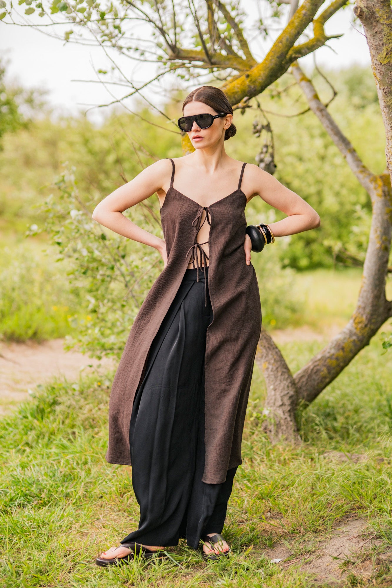 Woman wearing the Amaya Dress sewing pattern from Fibre Mood on The Fold Line. A dress pattern made in viscose, crepe, chambray, linen, polyester, or silk fabric, featuring spaghetti straps, front ties, and midi length.