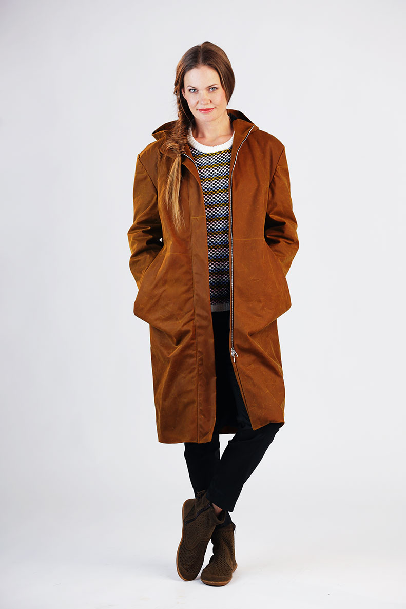 Woman wearing the Amy Parka sewing pattern from Schnittchen Patterns on The Fold Line. A coat pattern made in canvas, waxed cotton, wool, or plush fabric, featuring an oversized fit, dropped shoulders, front zip, hood, and pockets.