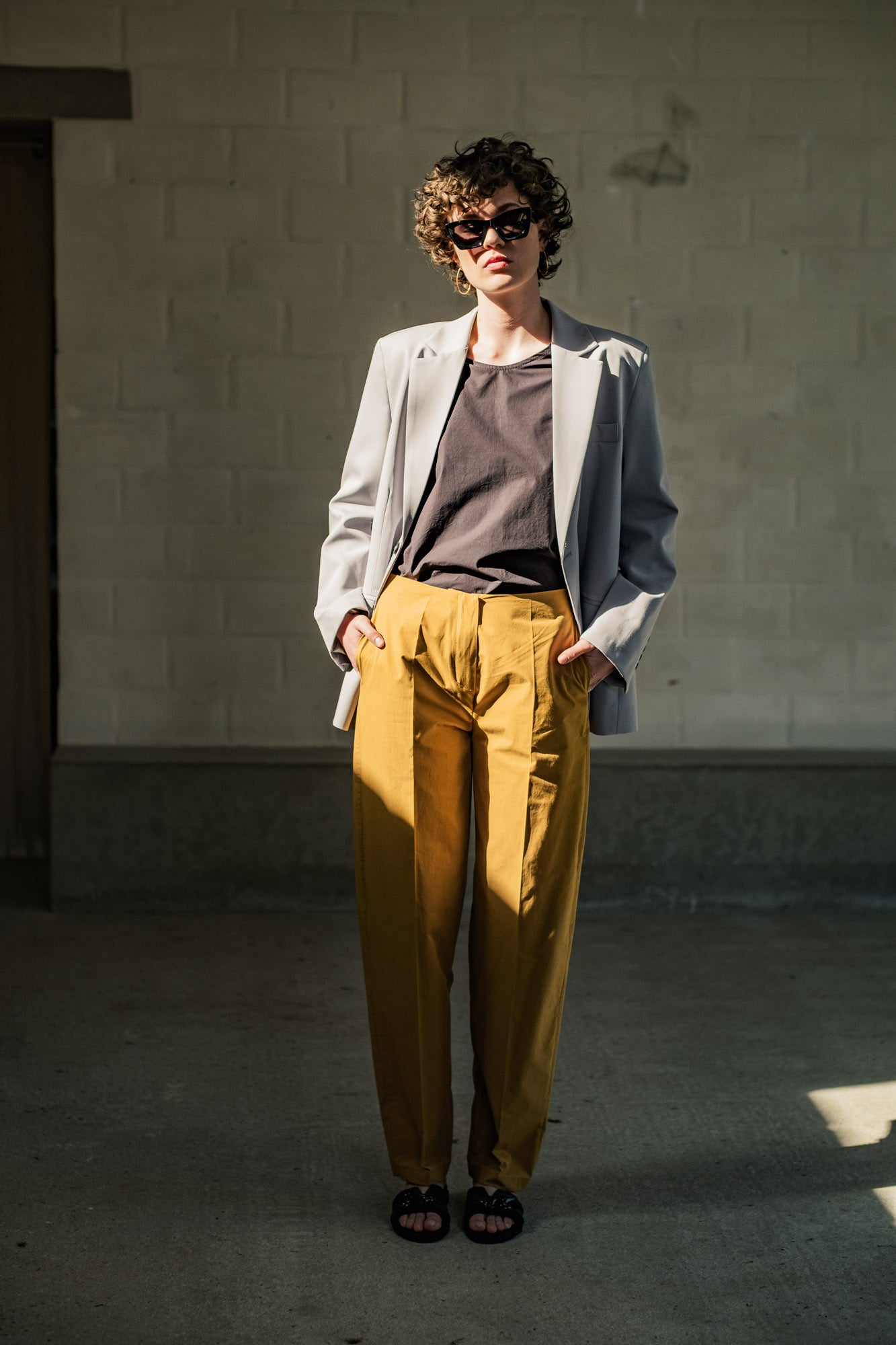 Woman wearing the Angela Trousers sewing pattern from Fibre Mood on The Fold Line. A trousers pattern made in poplin, denim, or wool fabric, featuring a zip fly, side pockets, and balloon leg.