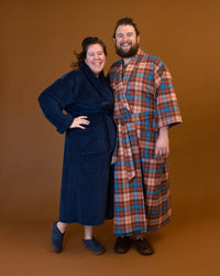 Man and woman wearing the Arbutus Robe sewing pattern from Helen's Closet on The Fold Line. A dressing gown pattern made in linen, cotton, silk, wool, hemp, rayon/viscose challis, satin, tencel, terry cloth, waffle, velour, or fleece fabric, featuring a relaxed fit, shawl collar, tie, and pockets.