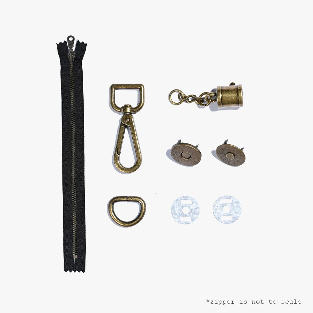 The Arch Clutch Hardware Kit from Kylie & The Machine on The Fold Line. Includes the metal hardware needed for the Arch Clutch sewing pattern: a lobster claw keychain, tassel chain and screw, magnetic clasp, D-ring, and closed-end YKK zipper.