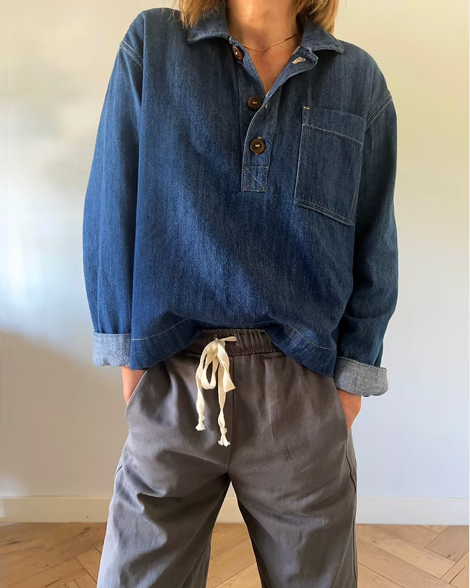 Woman wearing the Atlas Overshirt sewing pattern from French Navy on The Fold Line. A shirt pattern made in flannel, chambray, cotton, linen, denim, or corduroy fabric, featuring a boxy fit, convertible collar, partial button placket, dropped shoulders, long two-piece sleeves, and a patch pocket.