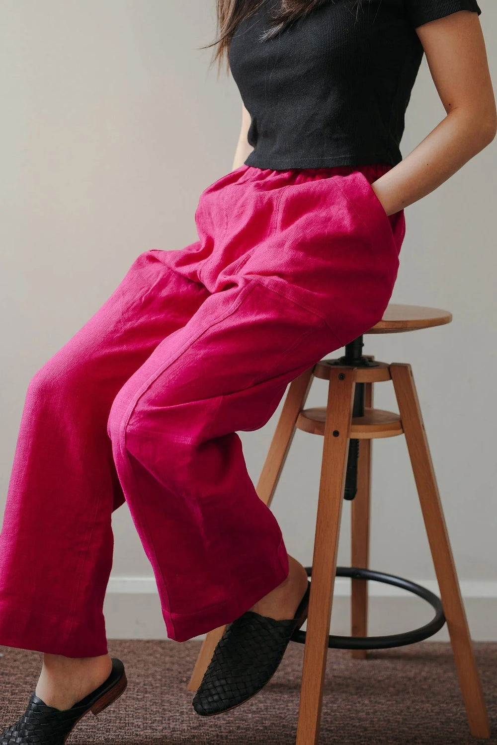 Woman wearing the Attwood Pants sewing pattern from In the Folds on The Fold Line. A pants pattern made in linen, linen blend, cotton canvas, cotton drill, or denim fabric, featuring a relaxed fit, elasticated waist, patchwork-esque panels, large patch pockets, straight leg, and cropped length.