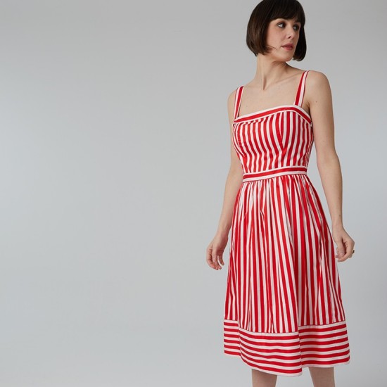 Woman wearing the Aurélie Dress sewing pattern from Coralie Bijasson on The Fold Line. A sundress pattern made in viscose crepe, linen, or cotton fabric, featuring a fitted bodice with thin straps and a gathered mid-calf length skirt. 