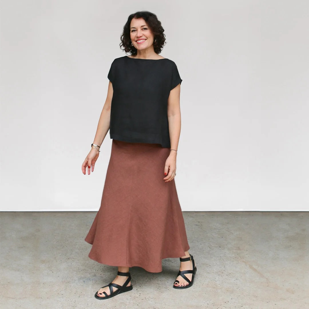 Woman wearing the Avery Skirt sewing pattern from Tessuti Fabrics on The Fold Line. A skirt pattern made in silk satin, satin backed crepe, viscose, linen, or lightweight wool fabric, featuring a bias cut, elastic waist, and silhouette that skims the hips and flares out towards the hem.