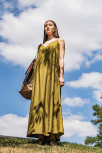 Woman wearing the Azure Dress sewing pattern from Fibre Mood on The Fold Line. A slip dress pattern made in drapey, crinkle jacquard, poplin, seersucker, or dobby fabric, featuring a deep V-neckline, thin straps, and maxi length.
