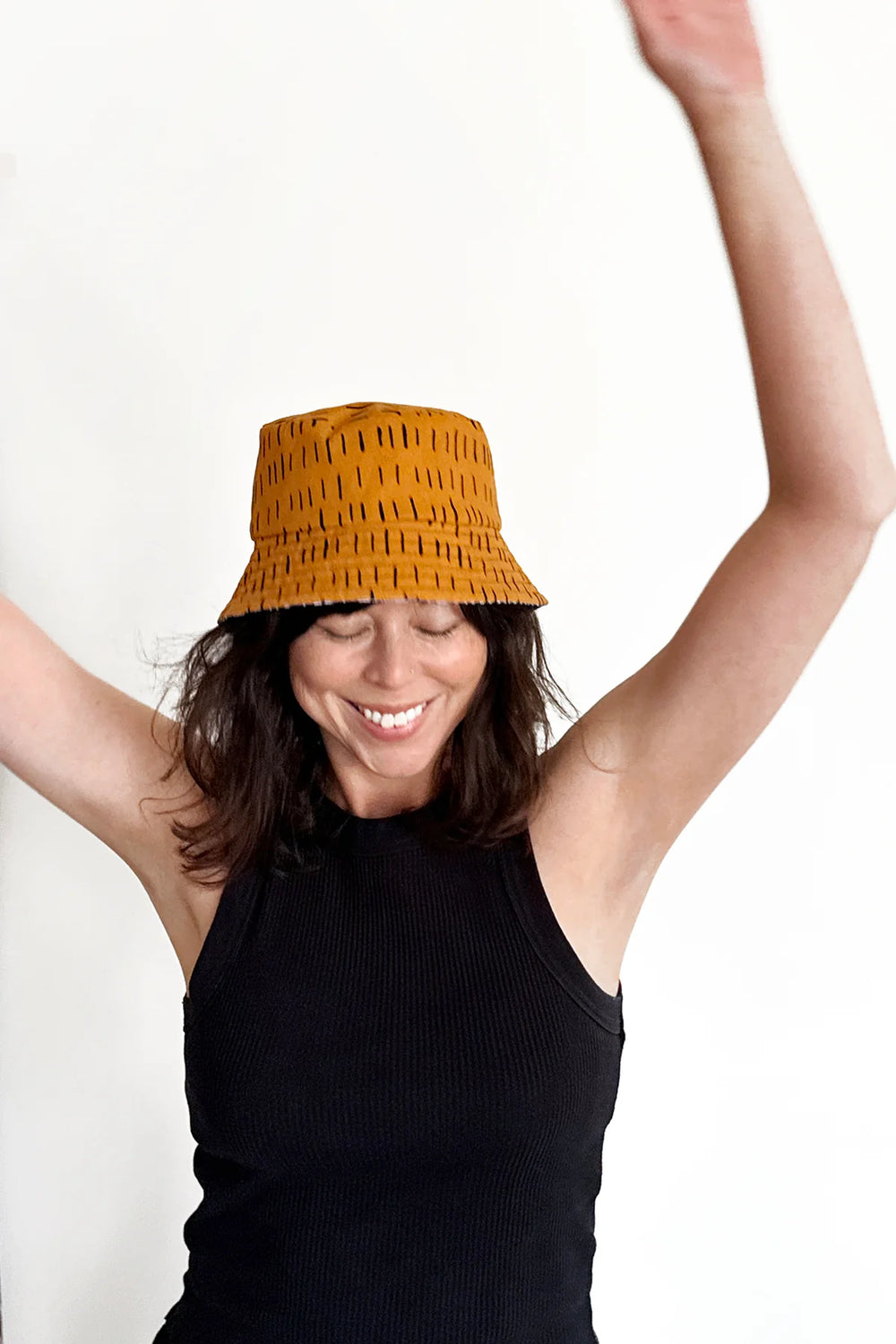 Woman wearing the Baby/Child/Adult Fairbank Hat sewing pattern from In the Folds on The Fold Line. A reversible bucket hat pattern made in cotton canvas, denim, cotton drill, corduroy, sherpa, fleece, heavy weight wool, tweed, velvet, terry towelling, or quilted fabric.