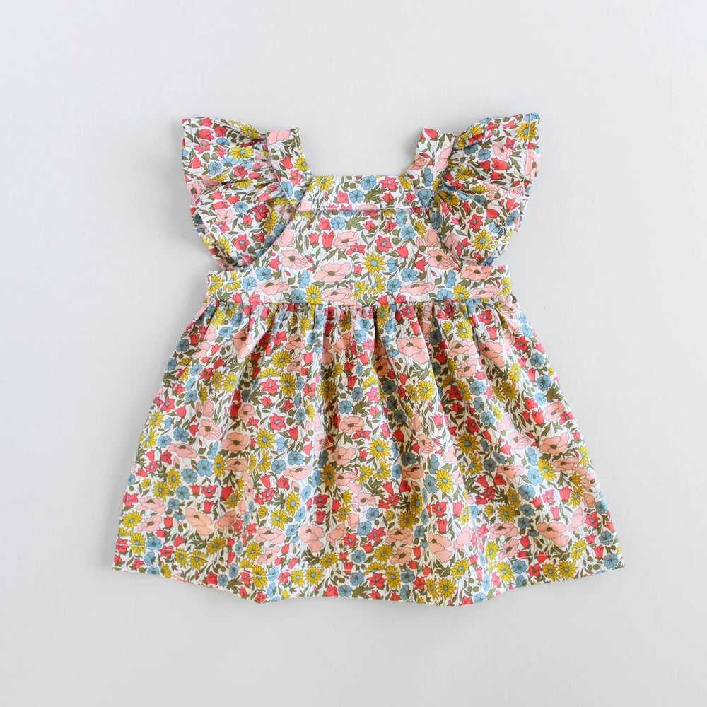 The Baby/Child Amelia Dress sewing pattern from Oh Me Oh My Sewing on The Fold Line. A dress pattern made in quilting cotton, washed linen, double gauze, cotton lawn, voile, or rayon challis fabric, featuring an oversized fit, square yoke, flutter sleeves, low back, high waist, and gathered skirt.