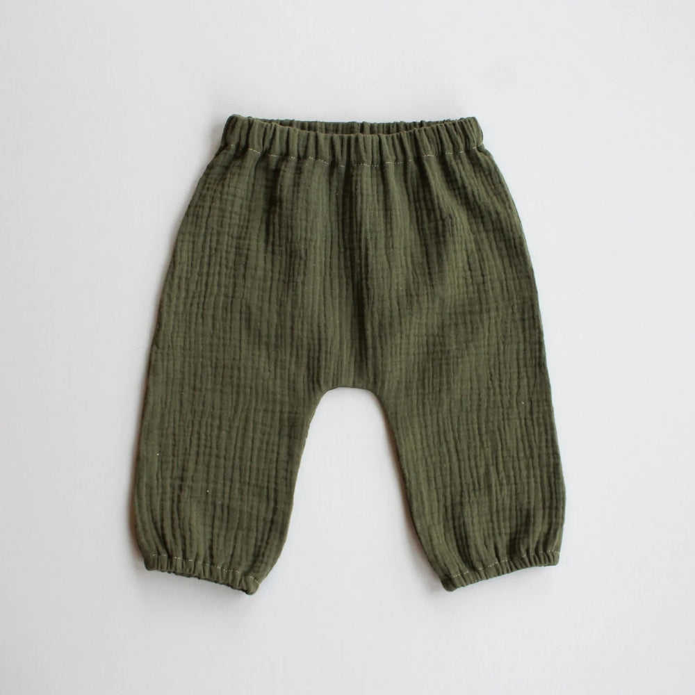 The Baby/Child August Pants sewing pattern from Oh Me Oh My Sewing on The Fold Line. A trousers pattern made in quilting cotton, washed linen, cotton lawn, or double gauze fabric, featuring an elastic waist and legholes and a gathered bubble silhouette.