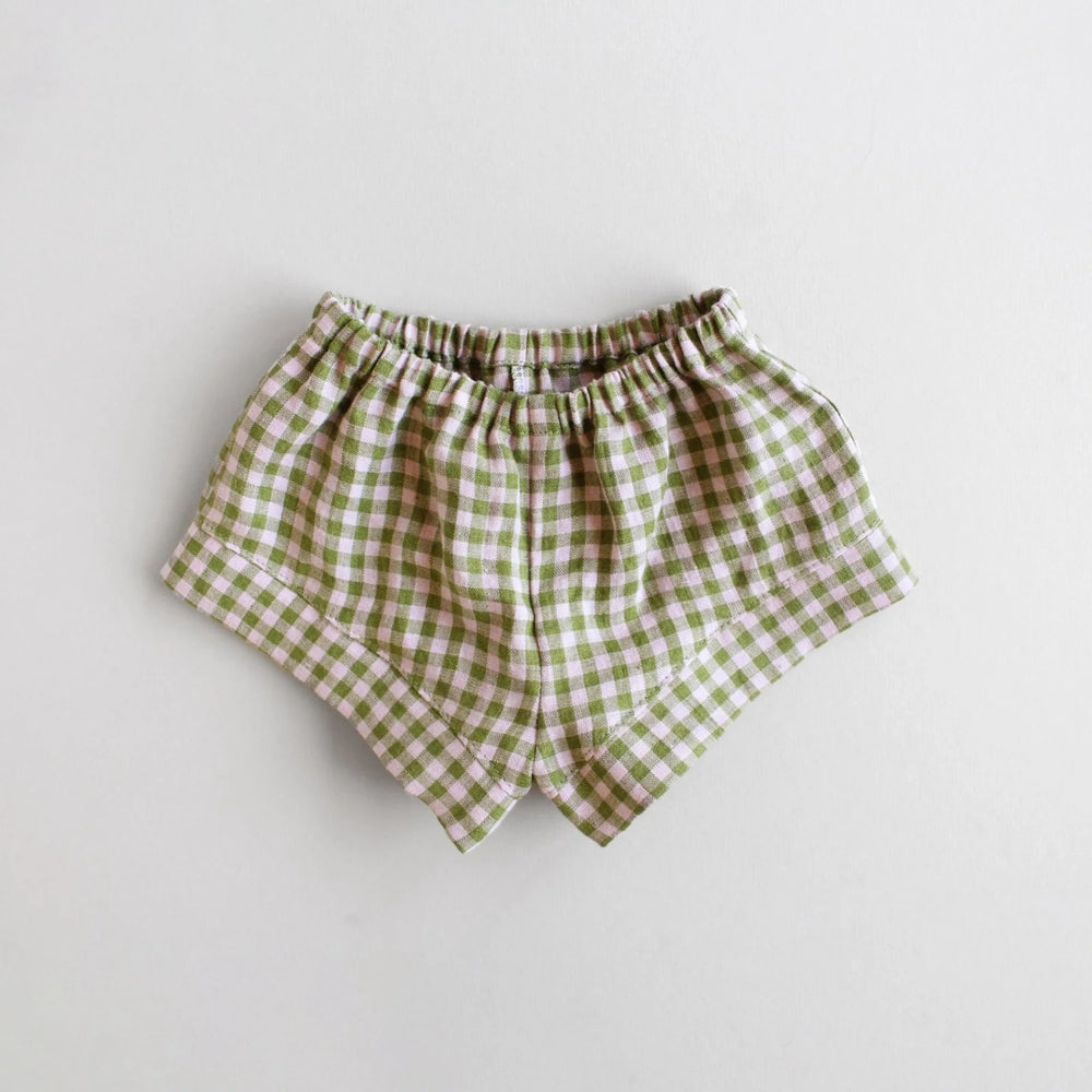 The Baby/Child Fauna Shorts sewing pattern from Oh Me Oh My Sewing on The Fold Line. A shorts pattern made in quilting cotton, washed linen, double gauze, cotton lawn, voile, or rayon challis fabric, featuring an elastic waist and comfy fit.
