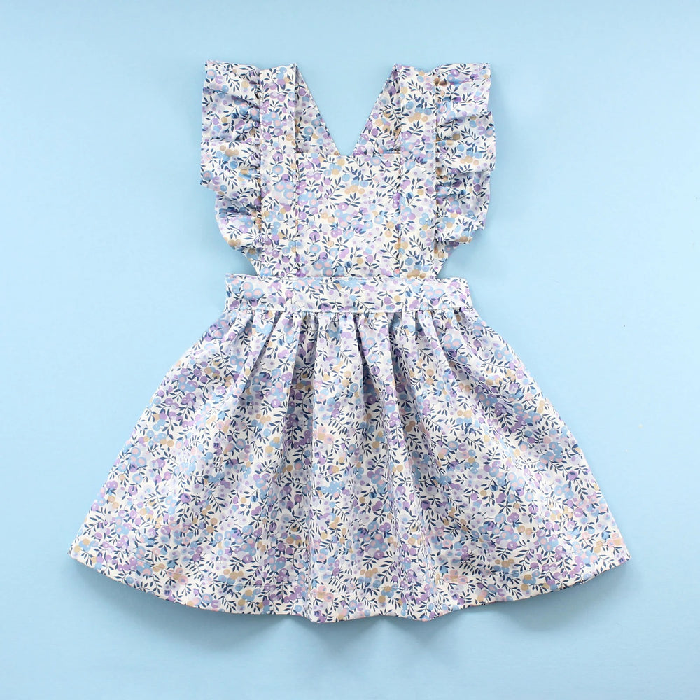 The Baby/Child Flutter Pinafore Dress sewing pattern from Oh Me Oh My Sewing on The Fold Line. A dress pattern made in quilting cotton, washed linen, double gauze, cotton lawn, voile, or rayon challis fabric, featuring a bib with ruffled straps and a full gathered skirt.