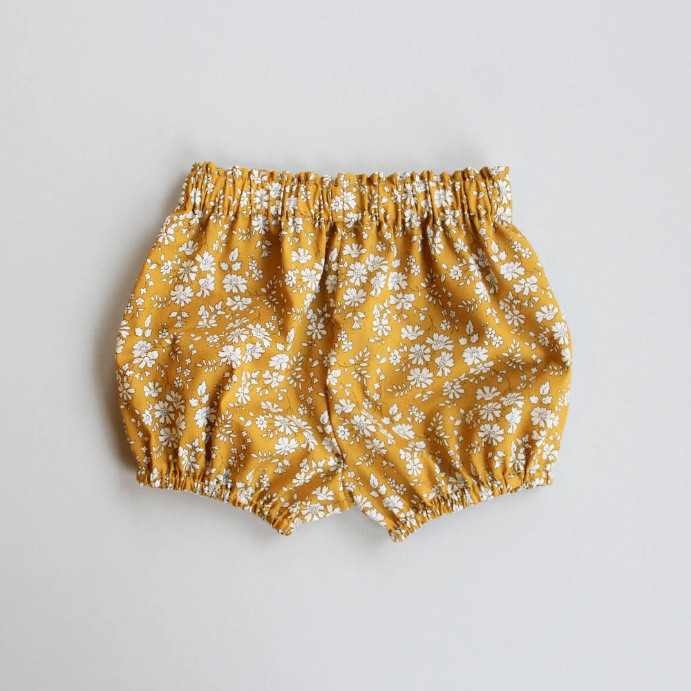 The Baby/Child Freya Bloomers sewing pattern from Oh Me Oh My Sewing on The Fold Line. A bloomers pattern made in quilting cotton, washed linen, double gauze, cotton lawn, voile, or rayon challis fabric, featuring a gathered bubble silhouette with an elastic waist and legholes.