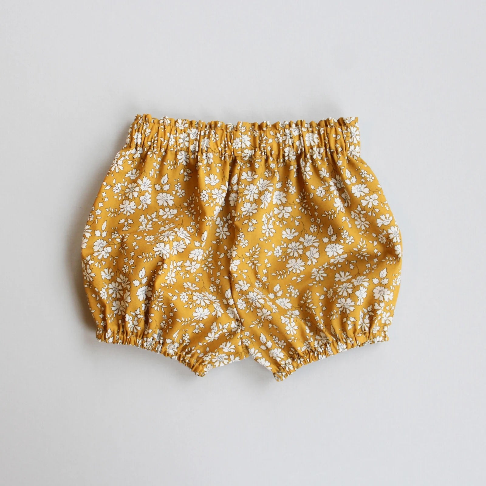 The Baby/Child Freya Bloomers sewing pattern from Oh Me Oh My Sewing on The Fold Line. A bloomers pattern made in quilting cotton, washed linen, double gauze, cotton lawn, voile, or rayon challis fabric, featuring a gathered bubble silhouette with an elastic waist and legholes.