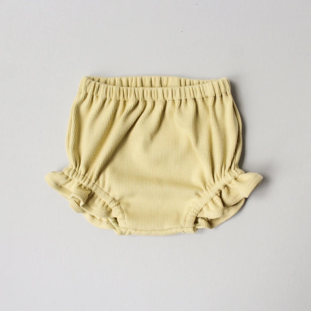 The Baby/Child Juniper Bloomers sewing pattern from Oh Me Oh My Sewing on The Fold Line. A bloomers pattern made in double gauze, waffle knit, jersey, or rib knit fabric, featuring a bubble silhouette, elastic waist, and elastic legholes with ruffles.