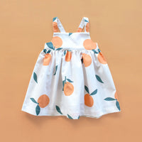 The Baby/Child Marigold Dress sewing pattern from Oh Me Oh My Sewing on The Fold Line. A dress pattern made in quilting cotton, washed linen, double gauze, cotton lawn, voile, or rayon challis fabric, featuring a square neckline, empire waist, elastic back, adjustable straps, and full gathered skirt.