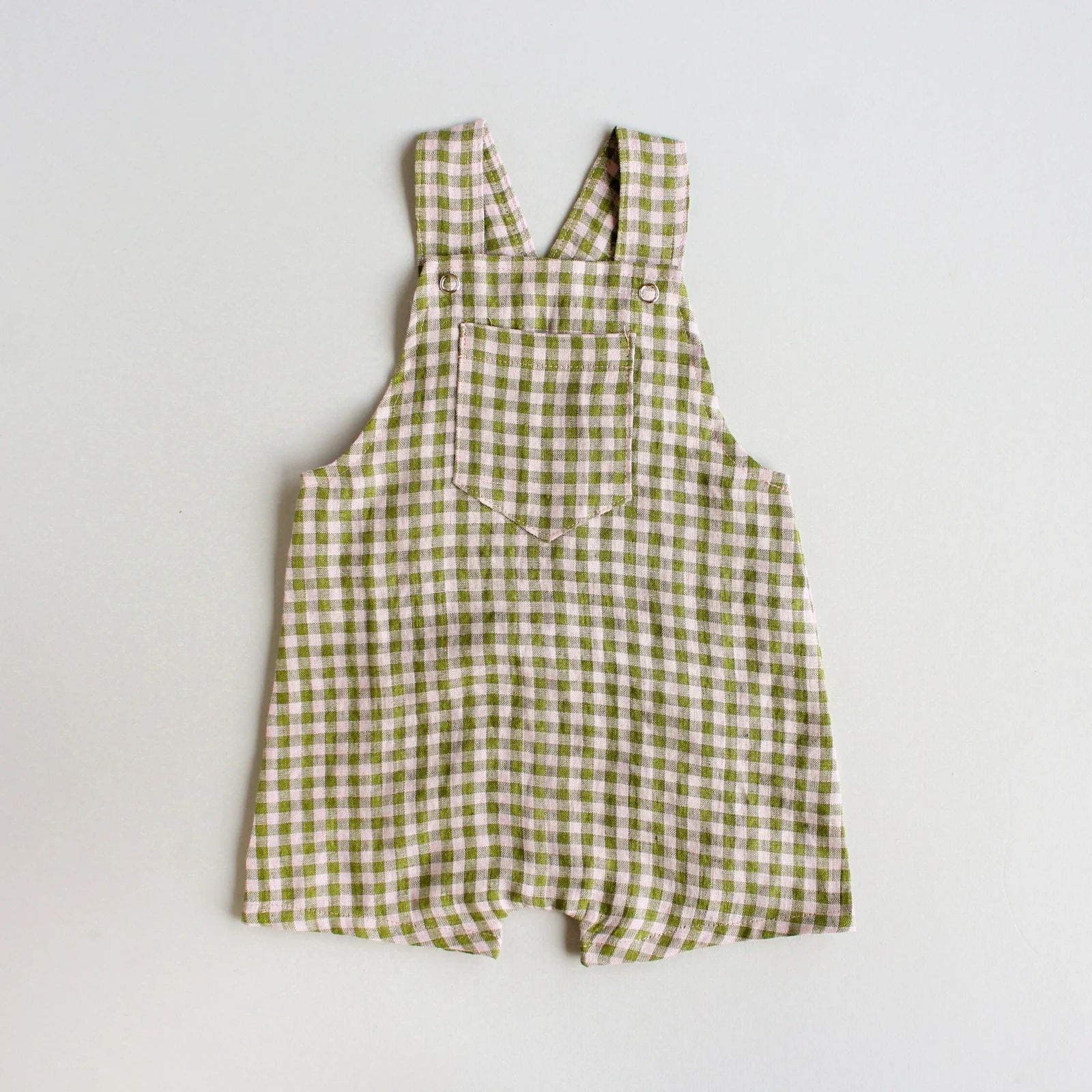 The Baby/Child Woven Overalls sewing pattern from Oh Me Oh My Sewing on The Fold Line. A dungarees pattern made in quilting cotton, lighter canvases, twill, corduroy, or washed linen fabric, featuring a patch pocket, adjustable straps, and shorts length.