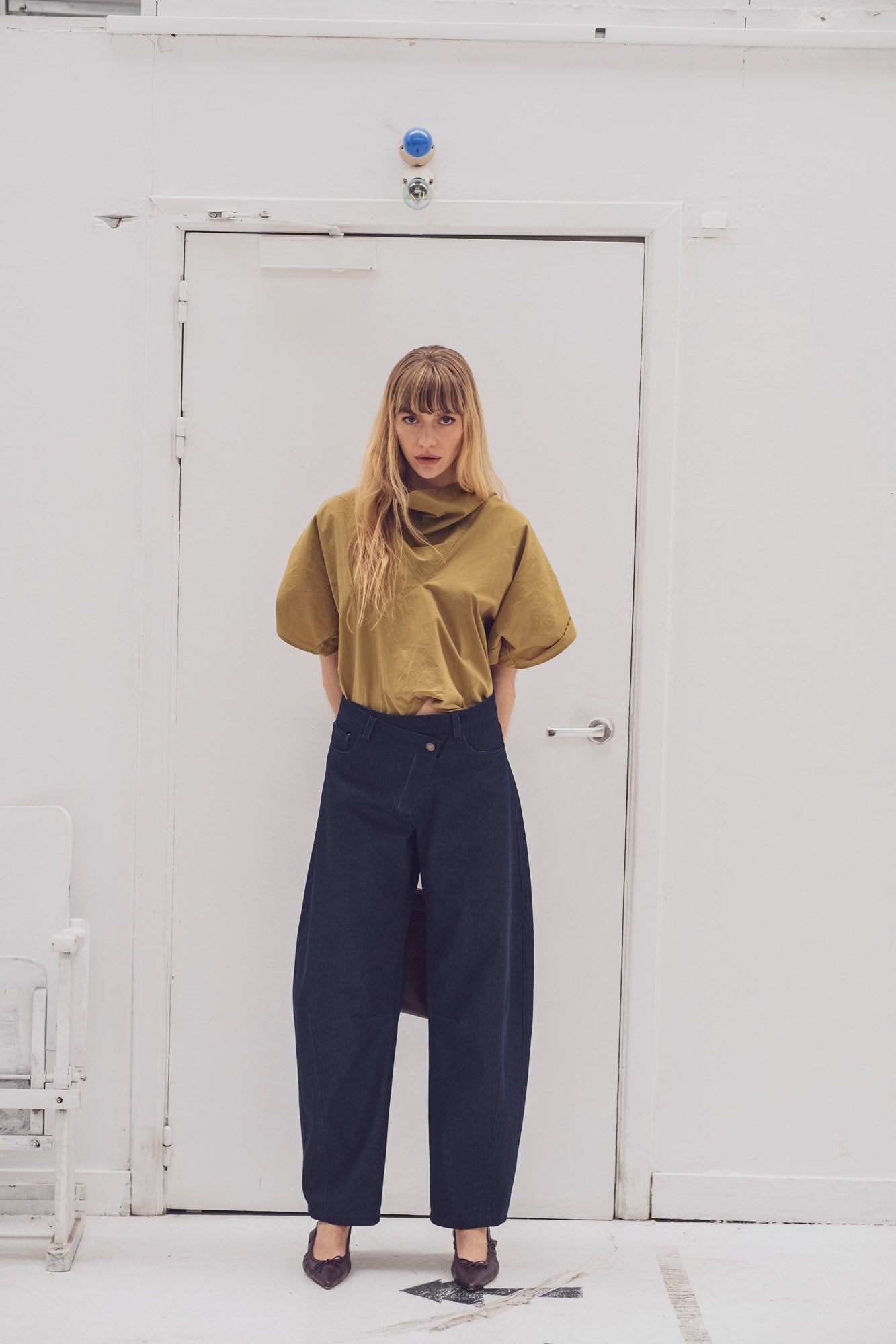 Woman wearing the Barbro Trousers sewing pattern from Fibre Mood on The Fold Line. A jeans pattern made in denim, twill, cotton blend, linen blend, or corduroy fabric, featuring an asymmetrical zip fly, front pockets, back yoke and patch pockets, and barrel leg.