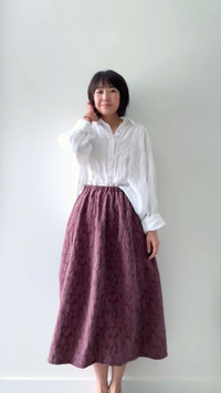 Woman wearing the Barrel Skirt sewing pattern from Sewing Therapy on The Fold Line. A skirt pattern made in cotton canvas or twill, linen, quilted cotton, jacquard, denim, chambray, or double gauze fabric, featuring an eight-panel construction, barrel shape, elastic waist, slant pockets, and midi length.
