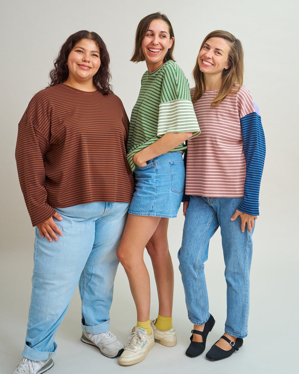 Women wearing the Benchwarmer Tee sewing pattern from Matchy Matchy Sewing Club on The Fold Line. A T-shirt pattern made in knit or jersey fabric, featuring an oversized fit, round neckline, dropped shoulders, and long or short sleeves.