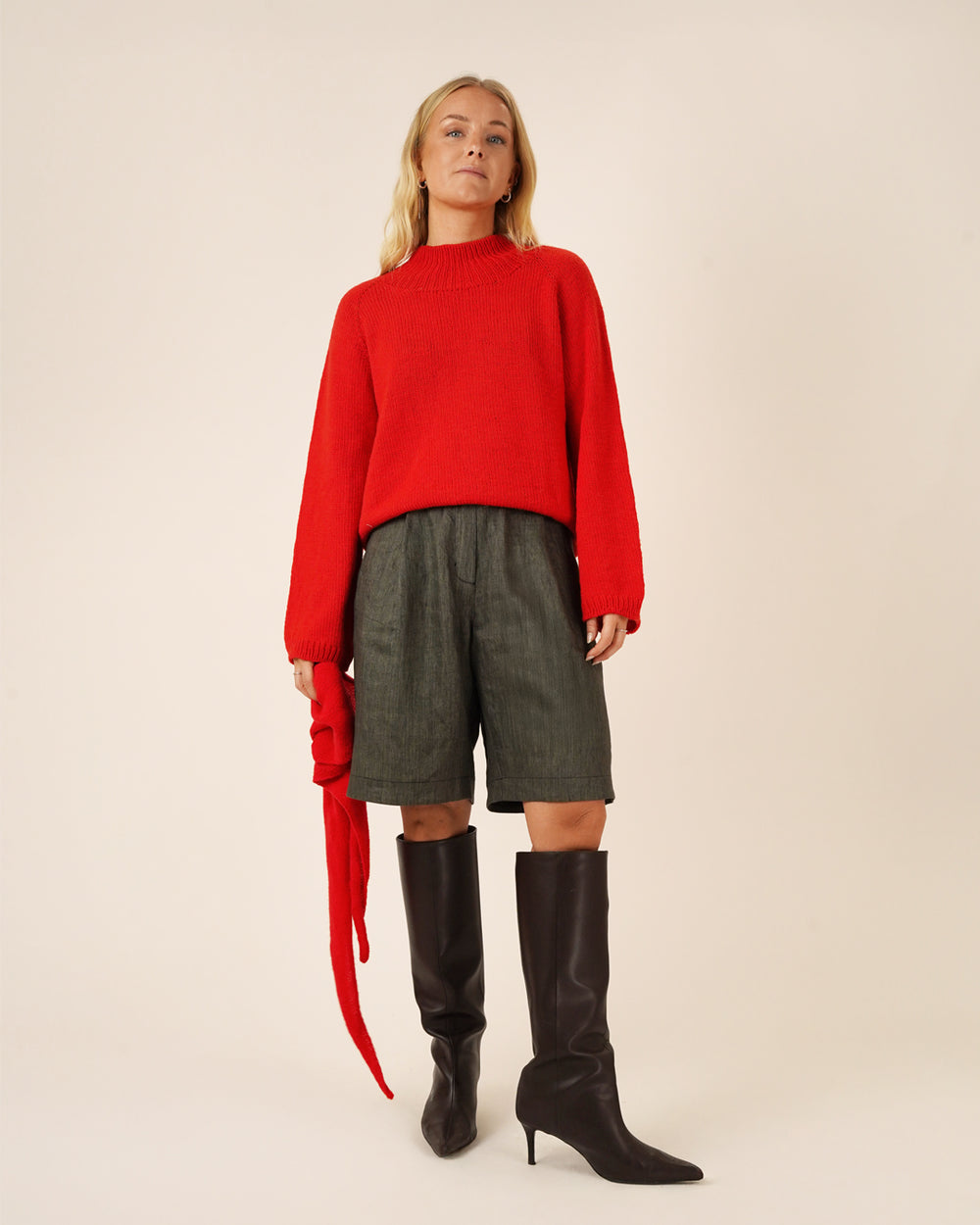 Woman wearing the Bermuda Shorts sewing pattern from Wardrobe by Me on The Fold Line. A shorts pattern made in cotton, wool, gabardine, or denim fabric, featuring a contoured waistband, zip fly, front pleats, side pockets, and back patch pockets.