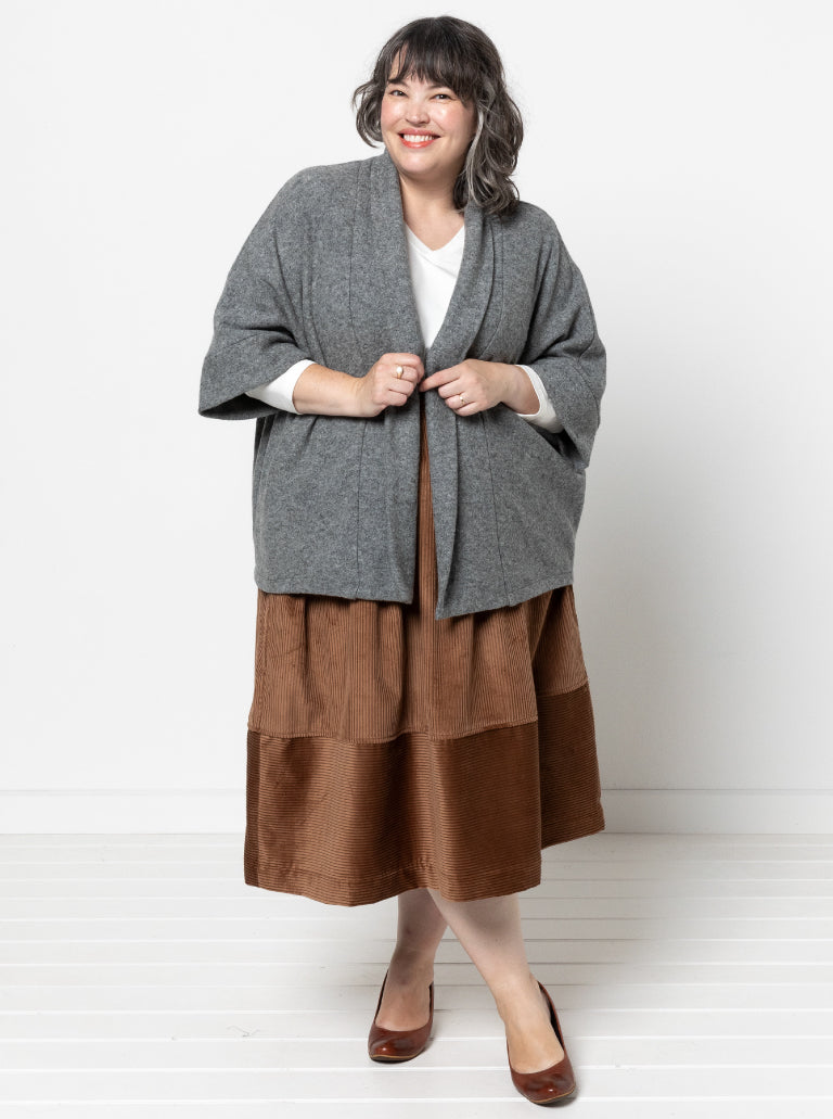Woman wearing the Besharl Jacket sewing pattern from Style Arc on The Fold Line. A jacket pattern made in cashmere, merino wool, boiled wool, ponte, or sweater knit fabric, featuring an open front, shawl collar, slight cocoon shape, and dropped back hemline.