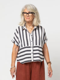 Woman wearing the Blaire Shirt sewing pattern from Style Arc on The Fold Line. A shirt pattern made in washed linen, crepe, chambray, or voile fabric, featuring a small shirt collar, button front, grown-on short sleeves with turn back cuffs, and an overlay.