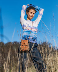 Woman wearing the Blaze T-shirt sewing pattern from Fibre Mood on The Fold Line. A form-fitting tee pattern made in knit fabric, featuring a crew neck and extra-long sleeves.