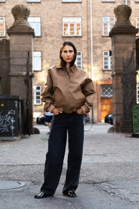 Woman wearing the Bomber Jacket sewing pattern from Puff and Pencil on The Fold Line. A jacket pattern made in denim, canvas, beaver nylon, or twill fabric, featuring a loose fit, collar, welt pockets, and rib trim.