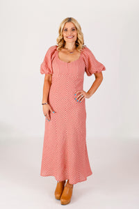 Woman wearing the Bora Dress sewing pattern from Chalk and Notch on The Fold Line. A dress pattern made in rayon challis, rayon twill, rayon voile, cotton lawn, cotton voile, linen, or chambray fabric, featuring a subtle V-neck fitted bodice with princess seaming, empire waist seam, short puff sleeves, A-line skirt, and maxi length.