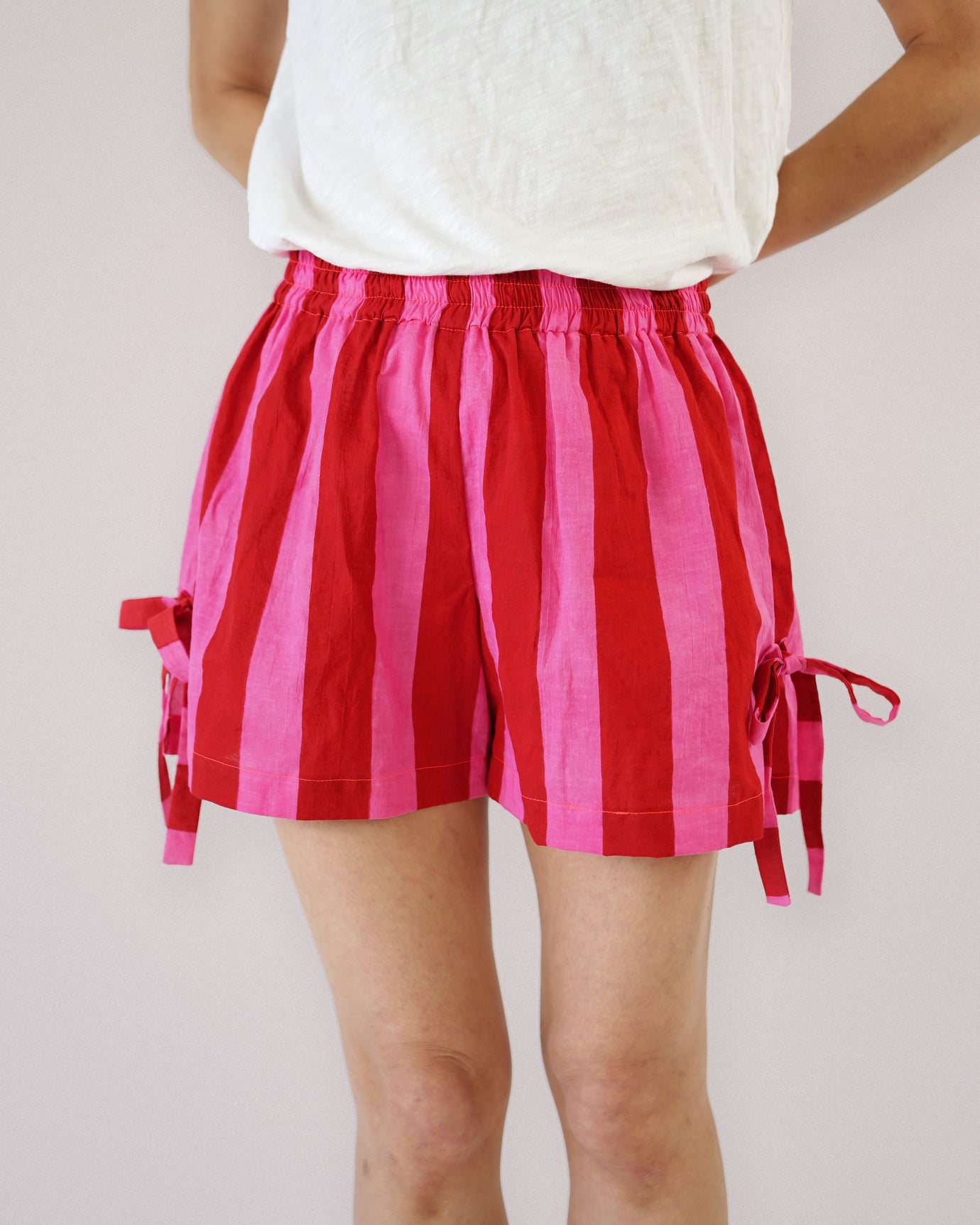 Woman wearing the Bow Boxer Shorts sewing pattern from Matchy Matchy Sewing Club on The Fold Line. A shorts pattern made in cotton or linen fabric, featuring a straight fit, elastic waist, and side slits with bows. 