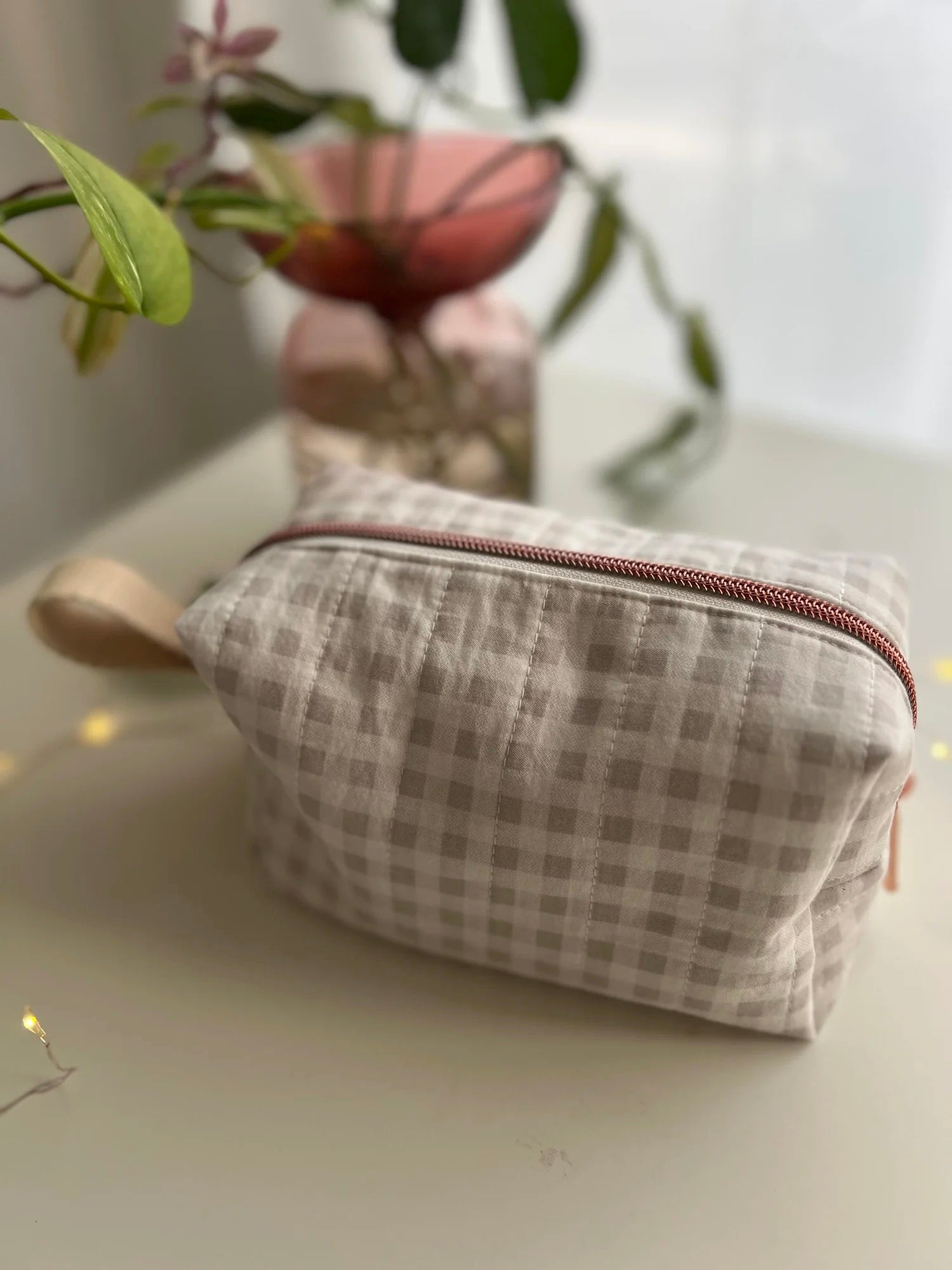 The Boxy Makeup Bag sewing pattern from Sew Bake Make on The Fold Line. A bag pattern made in quilting cotton or linen fabric, featuring a quilted body, zip top, and webbing tab.