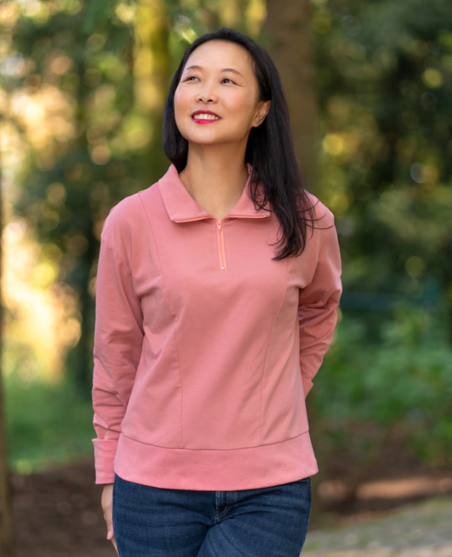 Woman wearing the Brisas Pullover sewing pattern from Itch to Stitch on The Fold Line. A top pattern made in knit fabric, featuring a stand-up collar, half-zip front, princess seams, dropped shoulders, and long sleeves.