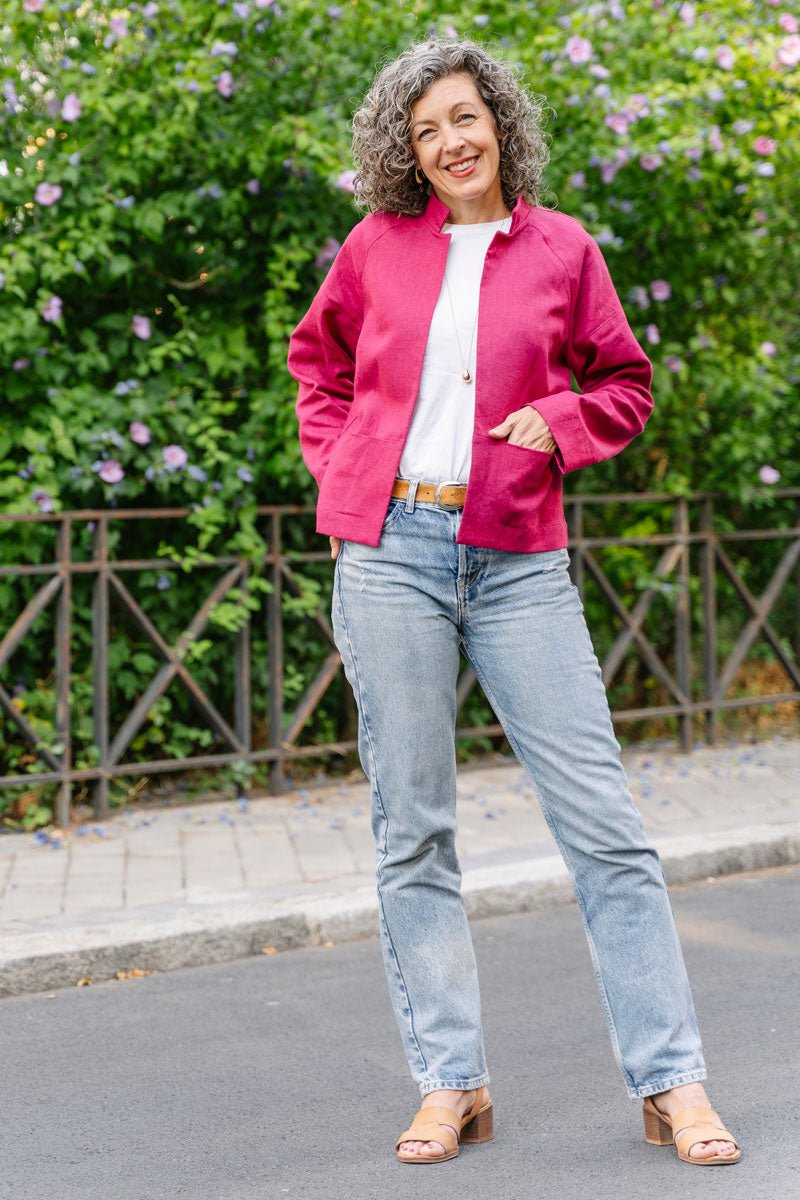 Woman wearing the Brunswick Jacket sewing pattern from Liesl + Co on The Fold Line. A jacket pattern made in chambray, linen, soft denim, textured cotton, twill, or wool fabric, featuring raglan sleeves, on-seam front pockets, and a simple stand-up collar.