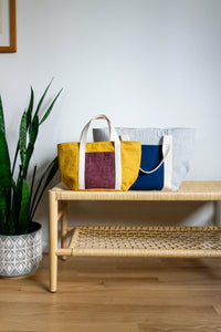 The Bucket Tote sewing pattern from Sew DIY on The Fold Line. A tote bag pattern made in canvas, denim, or corduroy fabric, featuring a full lining, oval base, exterior and interior pockets, webbing handles, and two sizes.