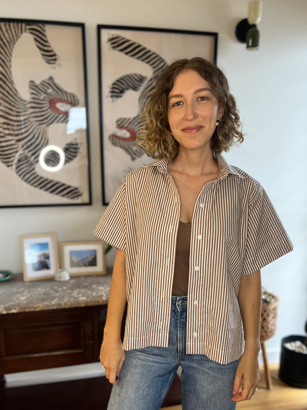 Woman wearing the Calla Shirt sewing pattern from Elle Stitch on The Fold Line. A shirt pattern made in cotton shirting, lightweight linen, or rayon linen blend fabric, featuring an oversized fit, collar and collar stand, button front, short sleeves, back yoke, and gathers along the back.
