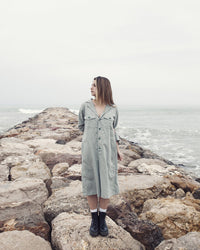 Woman wearing the Calvari Dress sewing pattern from Pauline Alice on The Fold Line. A shirt dress pattern made in cotton poplin, linen, corduroy, chambray, or flannel fabric, featuring a relaxed cut, notched collar, button front, back yoke, bracelet length sleeves, and pockets.