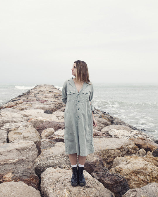 Woman wearing the Calvari Dress sewing pattern from Pauline Alice on The Fold Line. A shirt dress pattern made in cotton poplin, linen, corduroy, chambray, or flannel fabric, featuring a relaxed cut, notched collar, button front, back yoke, bracelet length sleeves, and pockets.