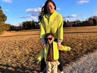Woman and boy wearing the Cardamom Quilt Jacket sewing pattern from Sew Bake Make on The Fold Line. A jacket pattern made in a lightweight thrifted quilt or quilted fabric, featuring a roomy fit, stand collar, and pockets.