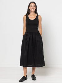 Woman wearing Carter Dress sewing pattern from Style Arc on The Fold Line. A dress pattern made in knit fabric for the bodice and linen, cotton poplin, voile, silk, or rayon for the skirt, featuring a sleeveless bodice with a scoop neck and midi length skirt with pockets.