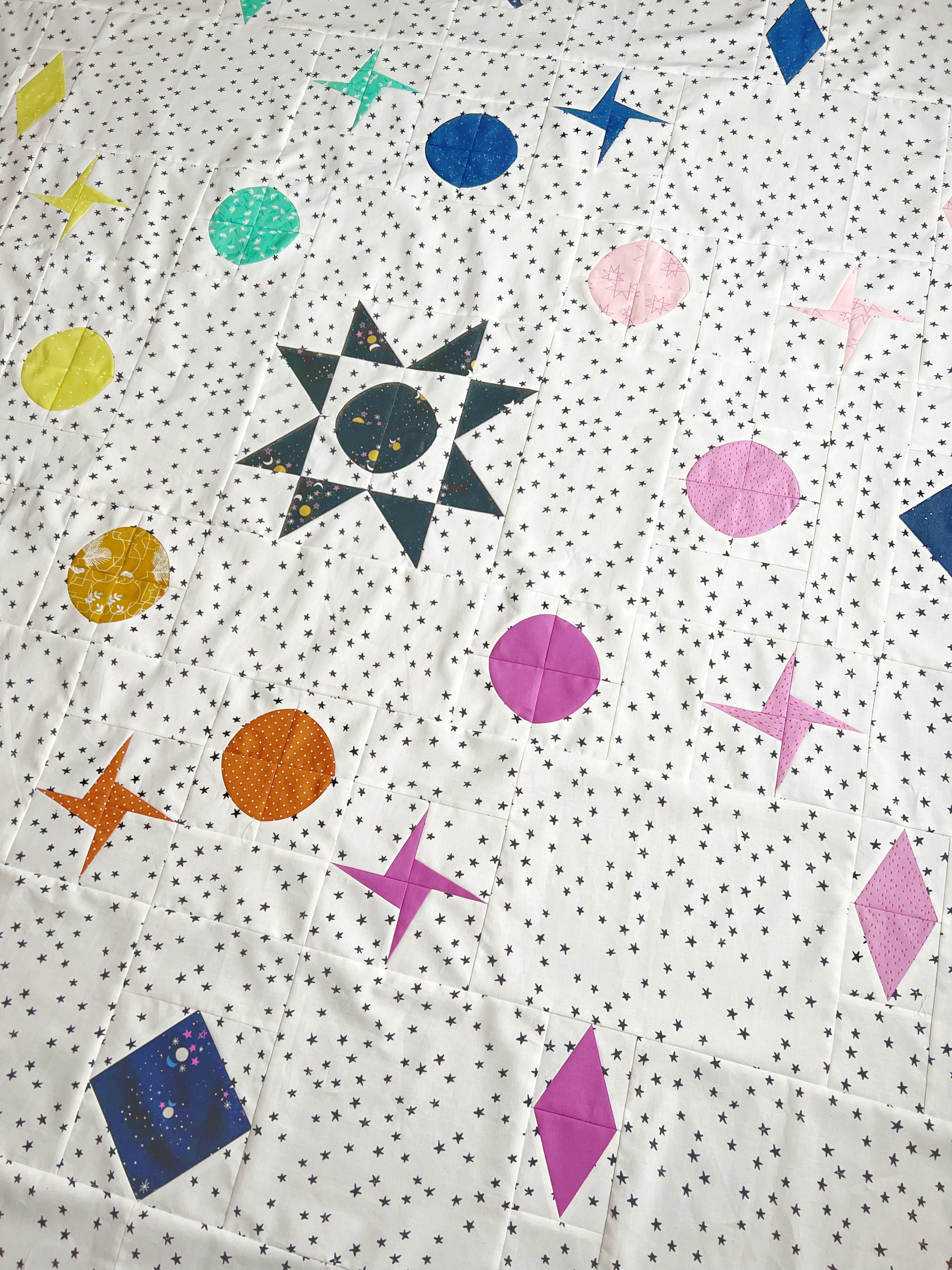 The Celestial Quilt sewing pattern from Lou Orth Designs on The Fold Line. A quilt pattern made in quilting cotton fabric, featuring a five-block design.