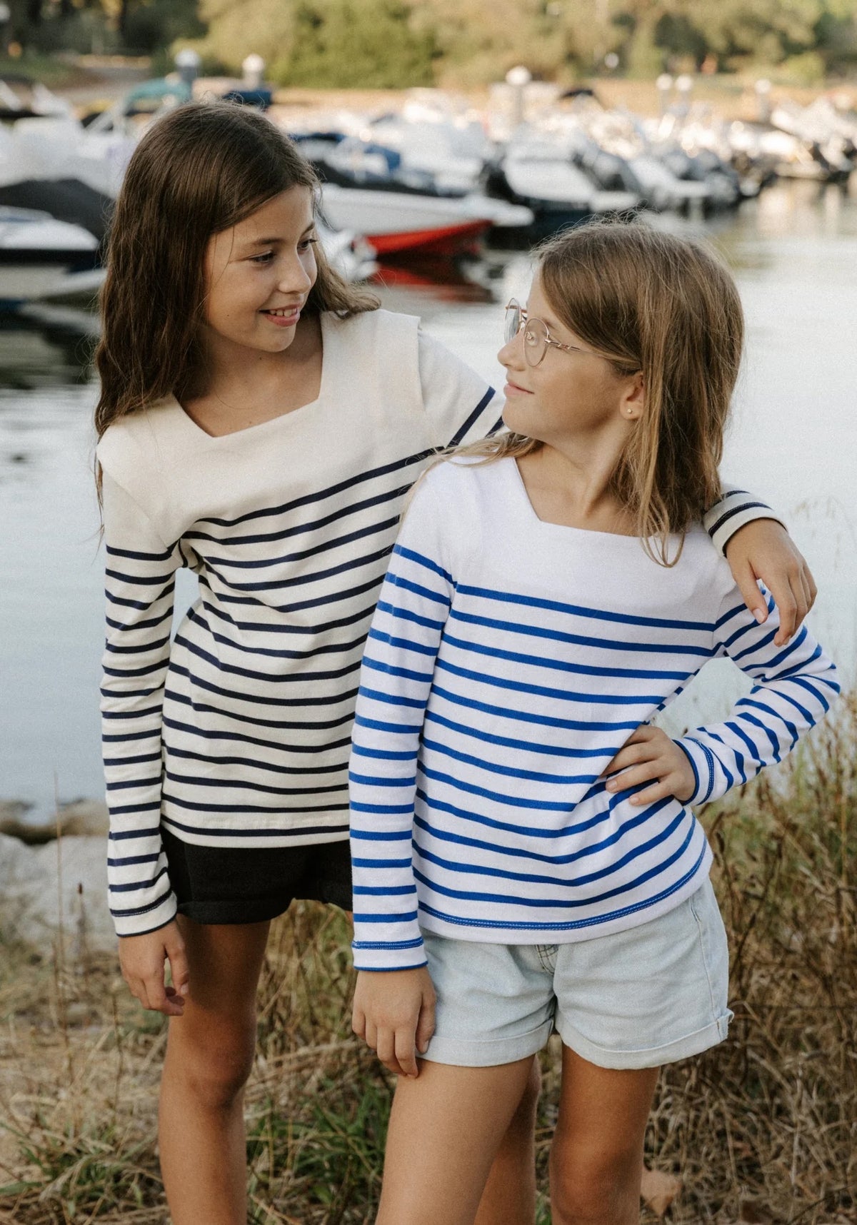 Girls wearing the Child/Teen Miss Pirate Breton Top sewing pattern from Maison Fauve on The Fold Line. A top pattern made in knit fabric, featuring a square neckline, shoulder pleats, and long sleeves.