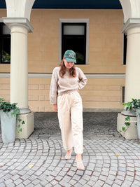 Woman wearing the Cilla Pants sewing pattern from Me & Kiddo Patterns on The Fold Line. A trousers pattern made in denim, twill, canvas, or linen fabric, featuring a relaxed fit, high rise, elasticated waist with a tie, straight leg, front slash pockets, back pockets, and cargo pockets.