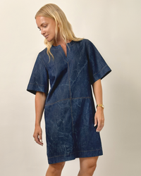 Woman wearing the City Dress sewing pattern from Wardrobe by Me on The Fold Line. A dress pattern made in denim, cotton twill, linen, chambray, or viscose-linen blend fabric, featuring a slightly A-line shape, notched neckline, wide elbow length sleeves, decorative seamlines, and above-the-knee length. 