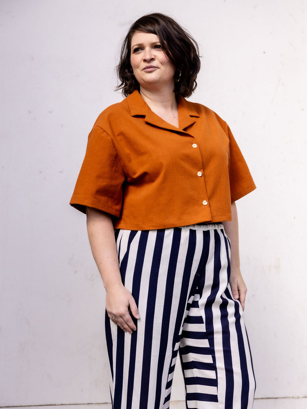 Woman wearing the Clara Shirt sewing pattern from Notches on The Fold Line. A shirt pattern made in viscose, tencel, cotton, chambray, or linen fabric, featuring a Cuban (camp) collar, button front, elbow length sleeves, and cropped length.