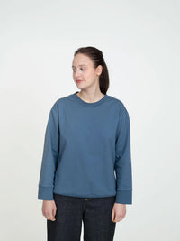 Woman wearing the Classic Sweatshirt sewing pattern from The Assembly Line on The Fold Line. A top pattern made in jersey fabric, featuring a relaxed fit, crew neck, and long sleeves with ribbed cuffs.