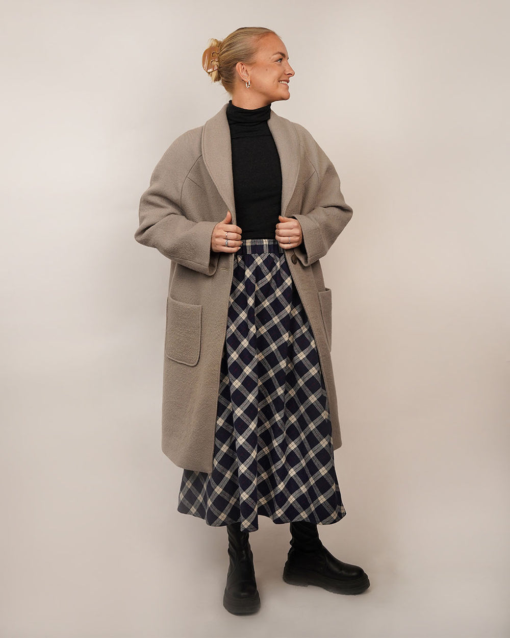 Woman wearing the Cocoon Coat sewing pattern from Wardrobe by Me on The Fold Line. A lined coat pattern made in wool or wool blend fabric, featuring an oversized silhouette, shawl collar, raglan sleeves, front patch pockets, and button closure.