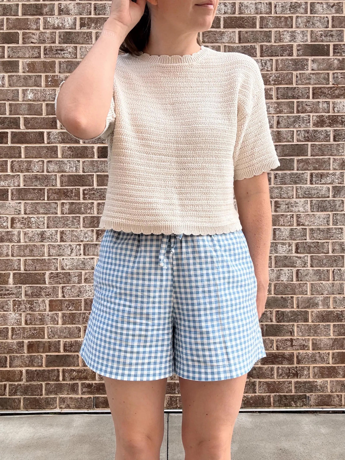 Woman wearing the Colette Shorts sewing pattern from Me & Kiddo Patterns on The Fold Line. A shorts pattern made in cotton, linen, double gauze, or denim fabric, featuring an elastic waist, side pockets, and drawstring tie.