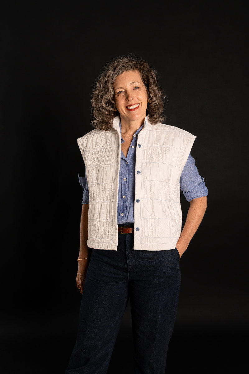 Woman wearing the Condesa Quilted Vest sewing pattern from Liesl + Co on The Fold Line. A quilted sleeveless vest pattern made in cotton poplin, sateen, lawn, voile, linen, rayon, or silk fabric, featuring an oversized boxy fit, stand collar, welt pockets, and button front.