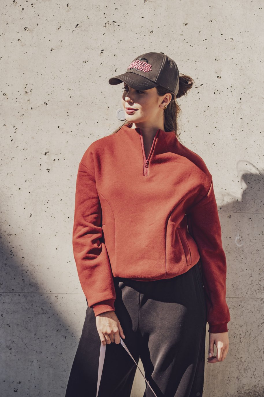 Woman wearing the Cruz Sweater sewing pattern from Fibre Mood on The Fold Line. A sweater pattern made in punto di Roma, microfibre jersey, fine modal jersey, French terry, sweater fabric, or softshell fabric, featuring a stand-up collar, zip fastening, curved front panels, welt pockets, and long sleeves.