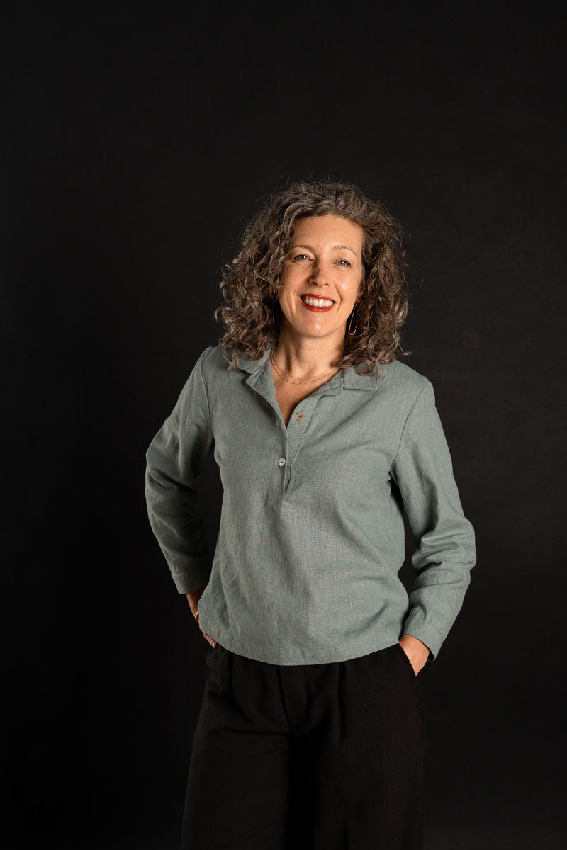 Woman wearing the Cyprus Woven Polo sewing pattern from Liesl + Co on The Fold Line. A polo shirt pattern made in cotton shirting, lawn, flannel, broadcloth, linen, rayon, double gauze, or cotton jersey fabric, featuring a collar, popover placket, bust darts, side vents, and long sleeves with cuffs.
